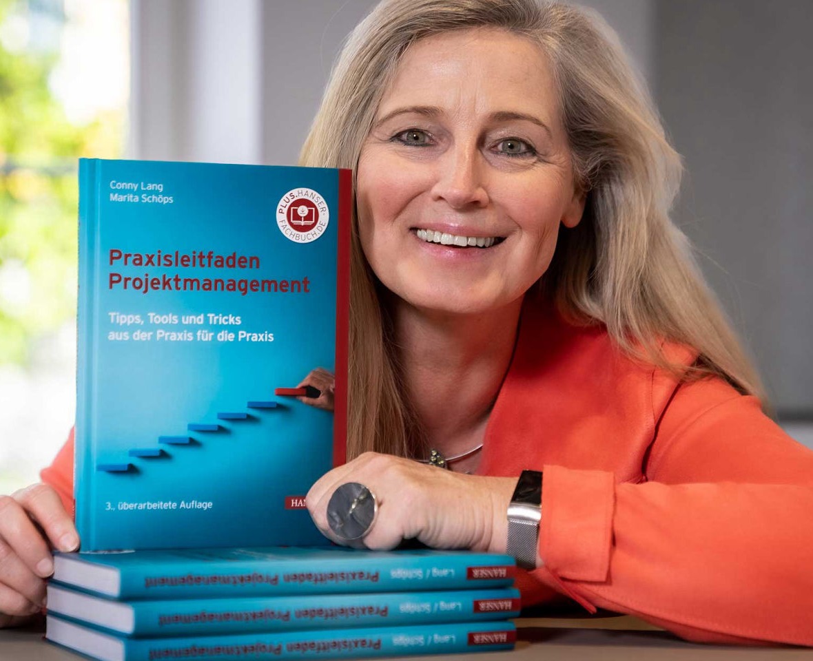 Conny Lang mit Stapel Bücher